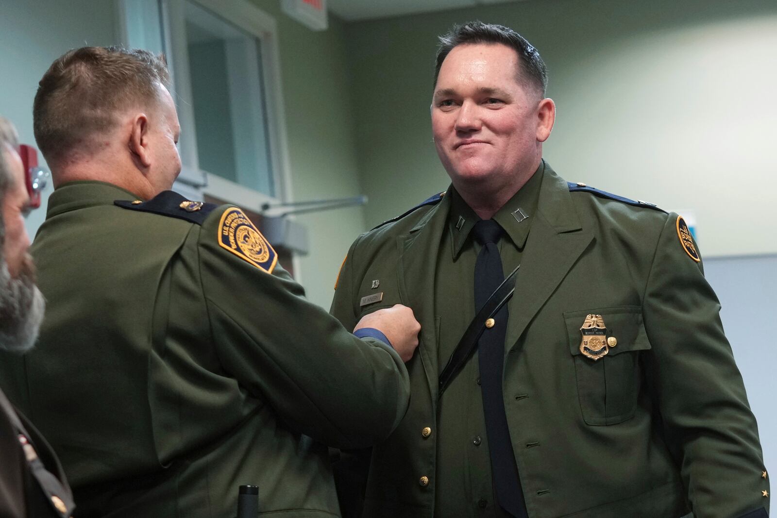 Border Patrol Agent Matthew A. Kiniery smiles as Chaplaincy program manager Spencer Hatch pins the chaplain pin on his uniform, Thursday, Nov. 21, 2024, in Dania Beach, Fla. (AP Photo/Marta Lavandier)