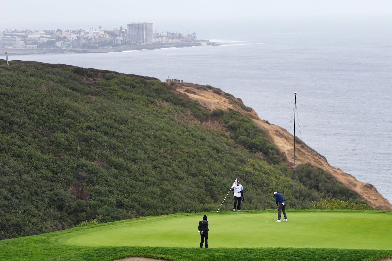 Scottie Scheffler putts on the third hole of the South Course at Torrey Pines during the first round of the Genesis Invitational golf tournament Thursday, Feb. 13, 2025, in San Diego. (AP Photo/Gregory Bull)