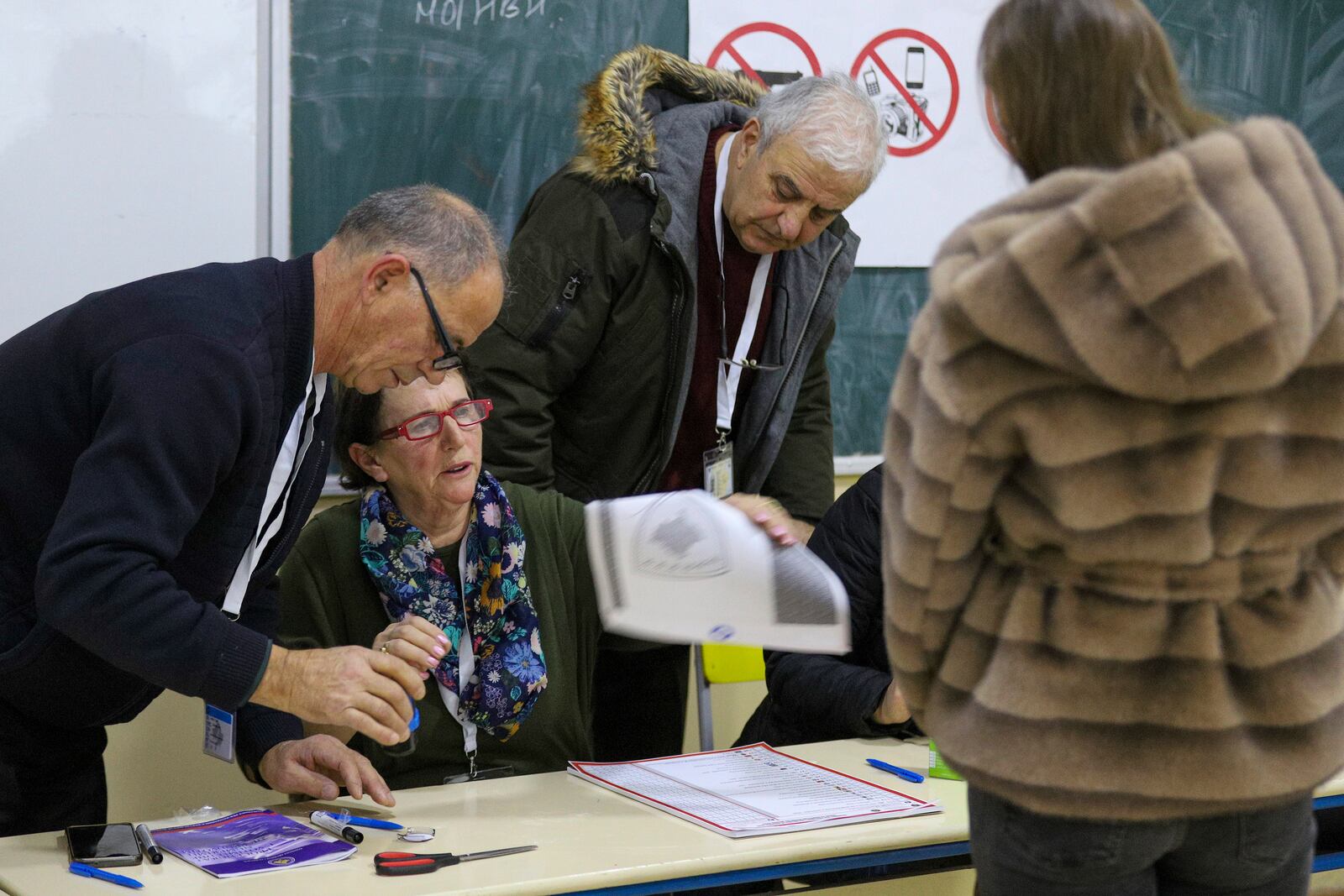 A voter waits for a ballot during a parliamentary election at a polling station in the northern Serb-dominated part of ethnically divided town of Mitrovica, Kosovo, Sunday, Feb. 9, 2025. (AP Photo/Bojan Slavkovic)