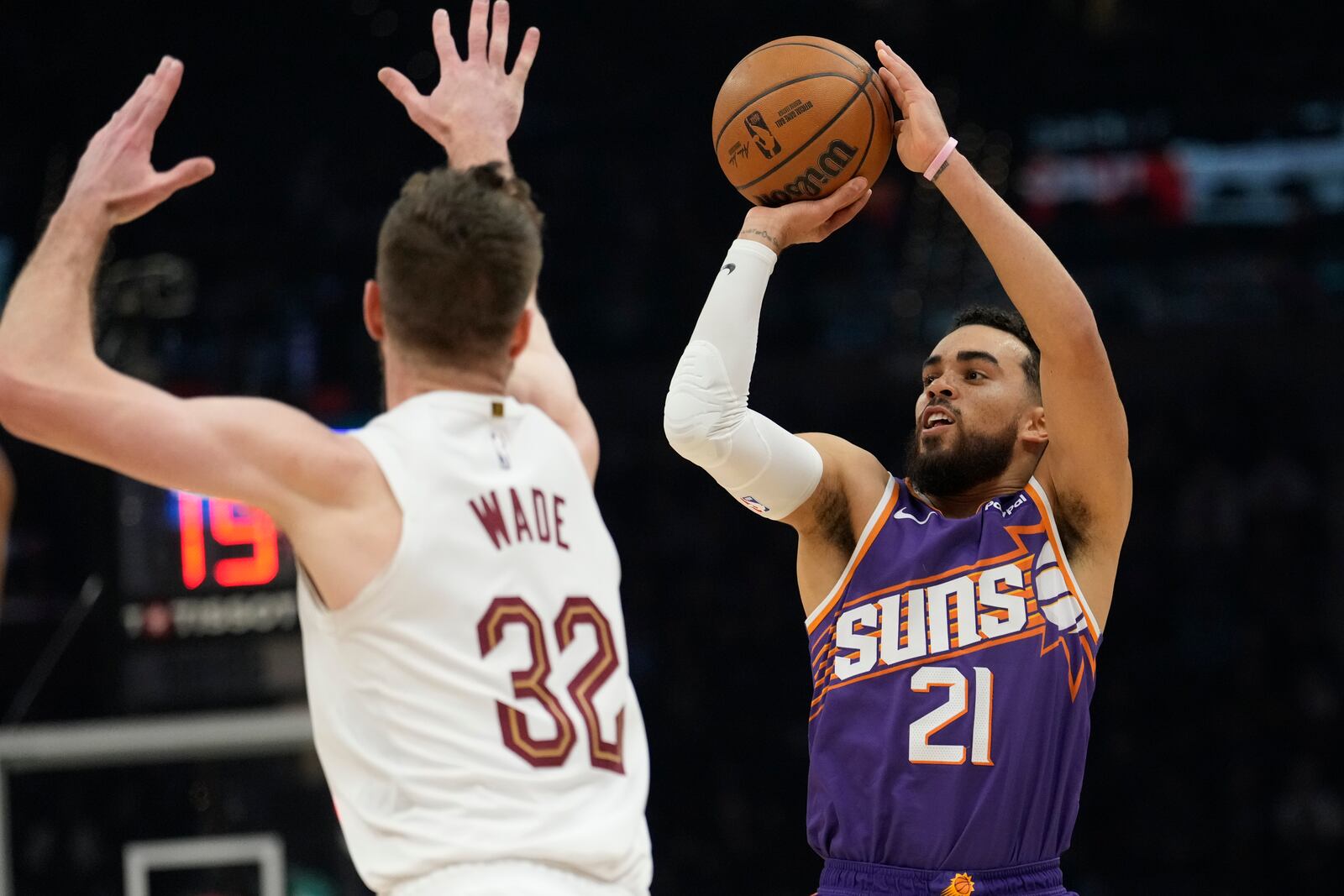 Phoenix Suns guard Tyus Jones (21) looks to shoot as Cleveland Cavaliers forward Dean Wade (32) defends in the first half of an NBA basketball game, Monday, Jan. 20, 2025, in Cleveland. (AP Photo/Sue Ogrocki)