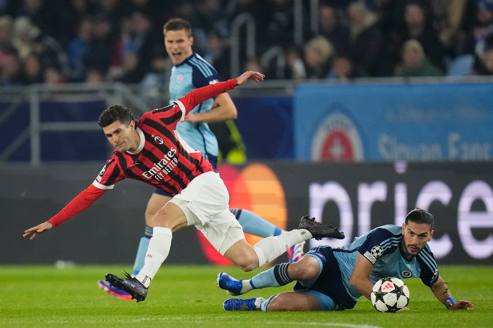 AC Milan's Christian Pulisic, left, Slovan's Kyriakos Savvidis fight for the ball during the Champions League opening phase soccer match between Slovan Bratislava and AC Milan in Bratislava, Slovakia, on Tuesday, Nov. 26, 2024. (AP Photo/Petr David Josek)