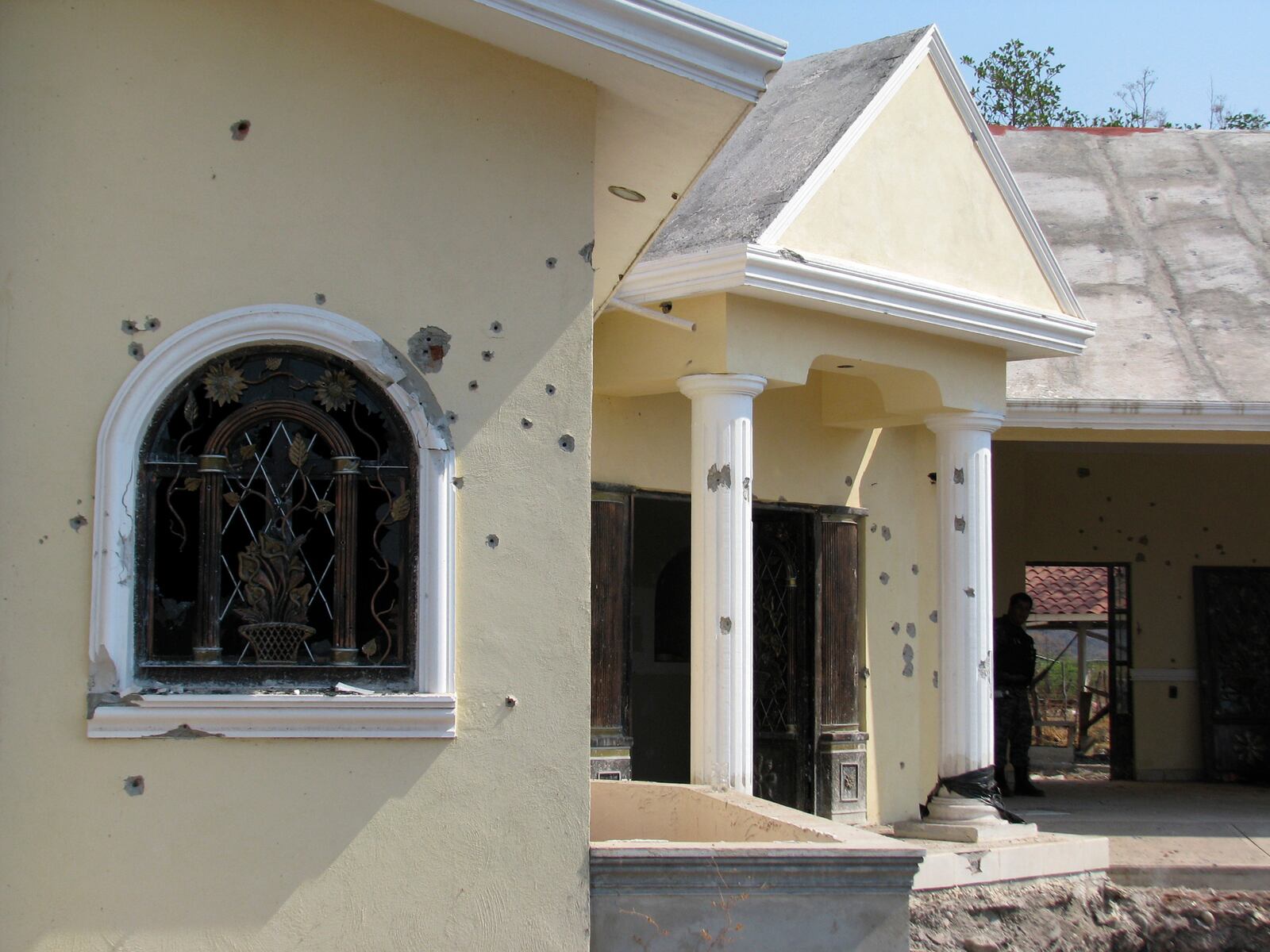 FILE - A home allegedly belonging to the La Familia Michoacana drug cartel is riddled with bullets after a gun battle the previous day between federal police and cartel members in Jilotlan, Mexico, May 28, 2011. (AP Photo/Raul Aguilar, File)