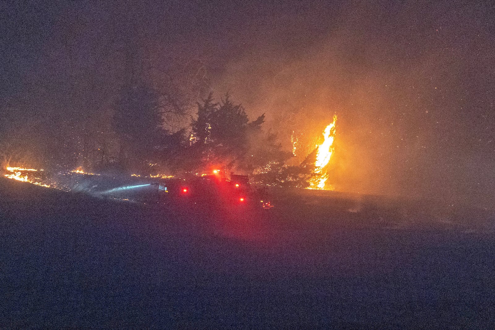 Fire crews from Coyle, Okla., battle a wildfire as it burns Friday, March 14, 2025, south of Langston, Okla. (AP Photo/Alonzo Adams)