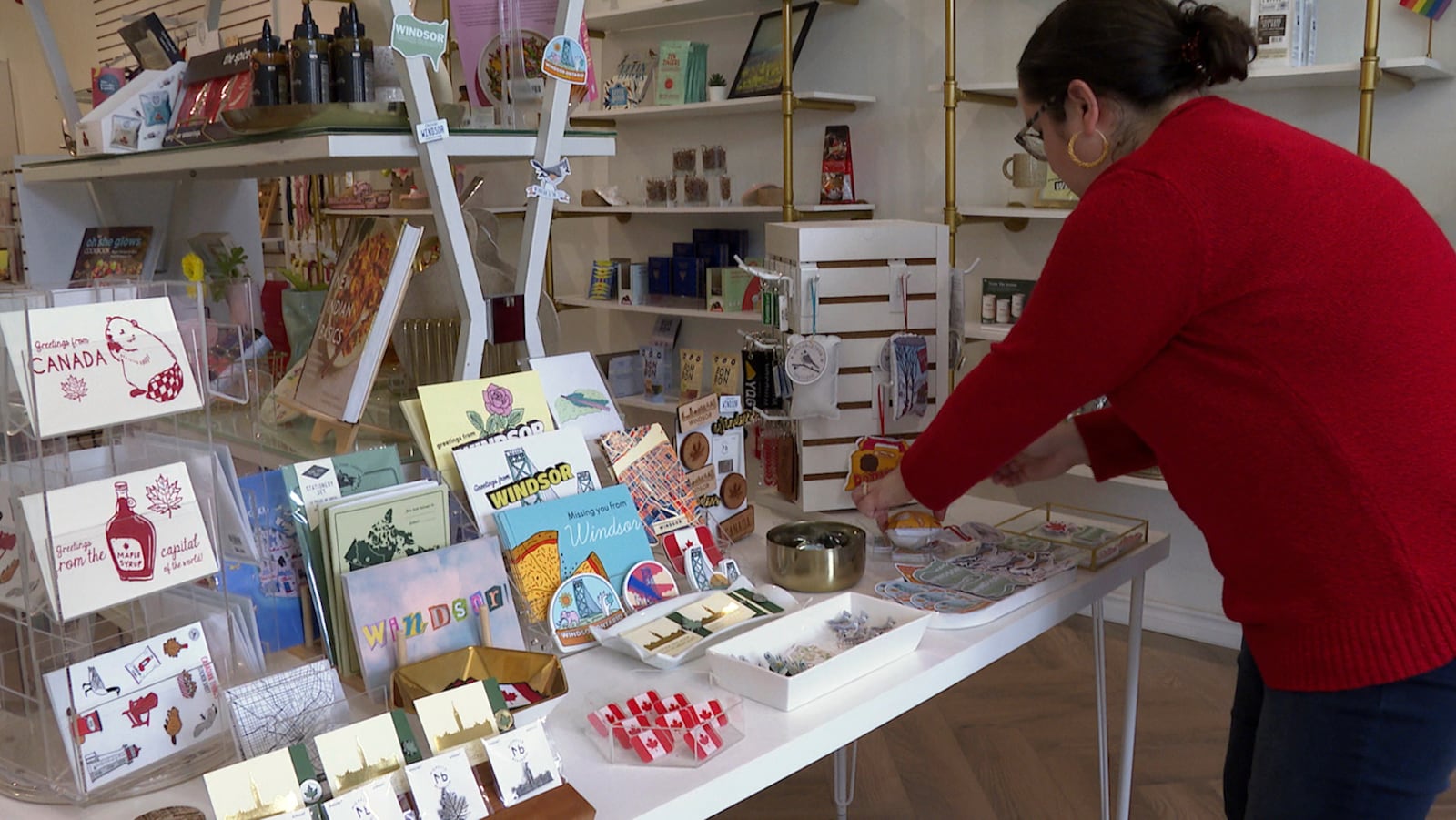 In this image made from video, Whiskeyjack Boutique owner Katie Stokes arranges items for sale at her gift shop Tuesday, March 4, 2025, in Windsor, Ontario. (AP Photo/Mike Householder)