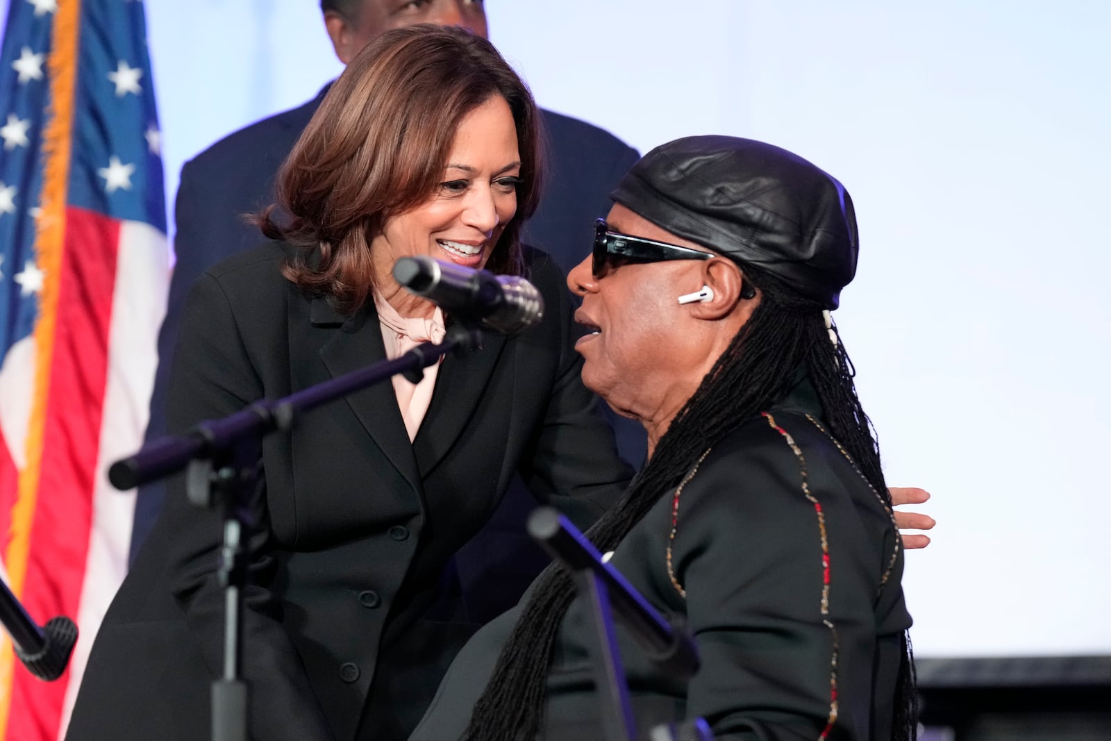 Democratic presidential nominee Vice President Kamala Harris, left, speaks with Stevie Wonder after he sang "Happy Birthday" to Harris during a church service and early vote event at Divine Faith Ministries International, Sunday, Oct. 20, 2024, in Jonesboro, Ga. (AP Photo/Jacquelyn Martin)