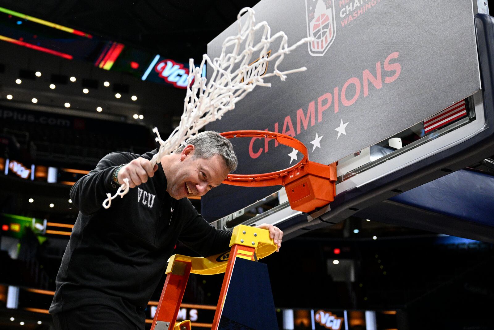 Virginia Commonwealth head coach Ryan Odom swings the net after cutting it down after winning an NCAA college basketball game in the championship of the Atlantic 10 tournament against George Mason, Sunday, March 16, 2025, in Washington. (AP Photo/Nick Wass)