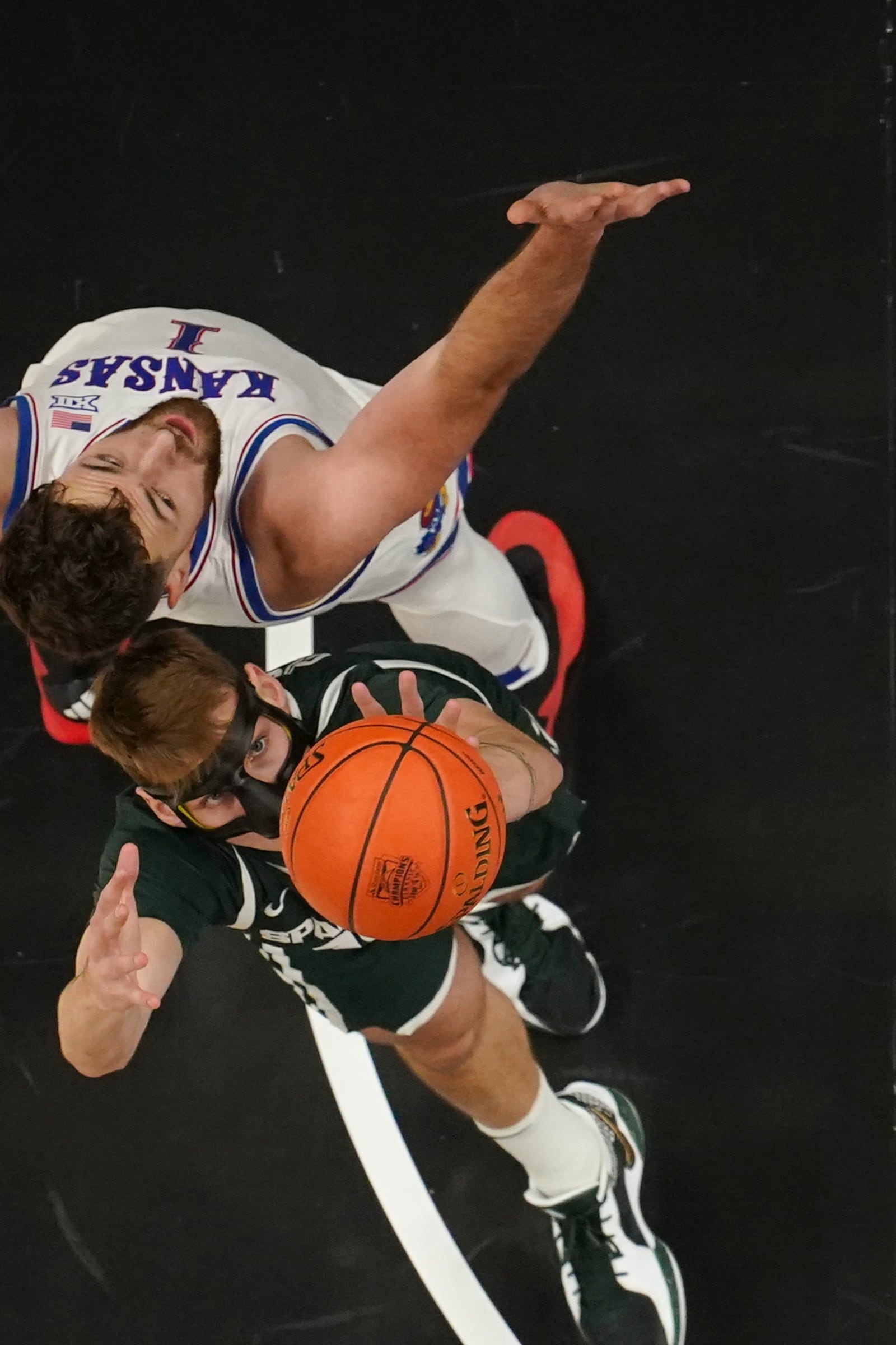 Michigan State center Carson Cooper (15) grabs a rebond in front of Kansas center Hunter Dickinson (1) during the first half of an NCAA college basketball game, Tuesday, Nov. 12, 2024, in Atlanta. (AP Photo/John Bazemore )