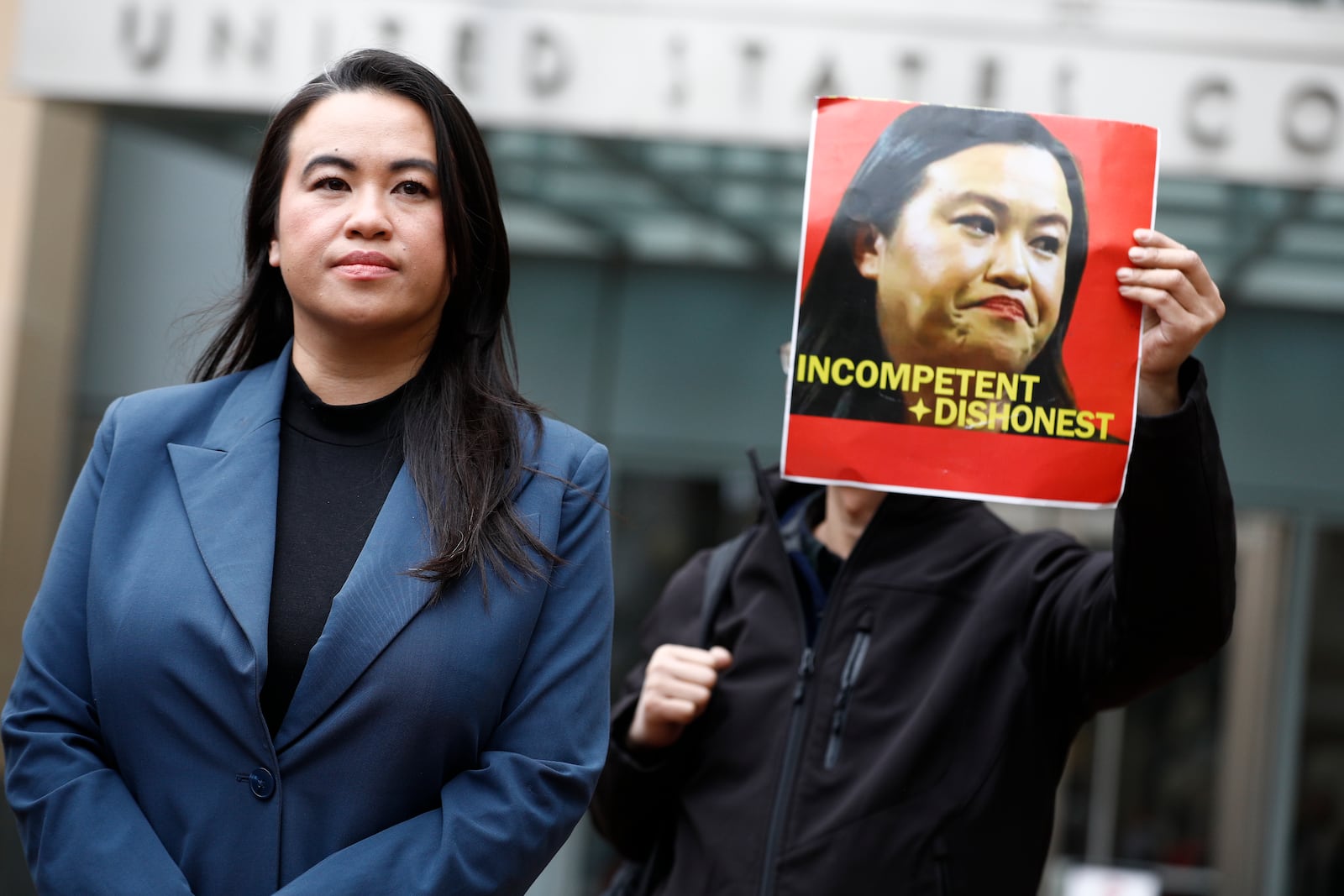 Former Oakland Mayor Sheng Thao stands in front of the United States District Court for a press conference following her arraignment of federal charges in Oakland, Calif., Friday, Jan. 17, 2025, as Tuan Ngo, founder of Asians Unite, protests at right. (Santiago Mejia/San Francisco Chronicle via AP)