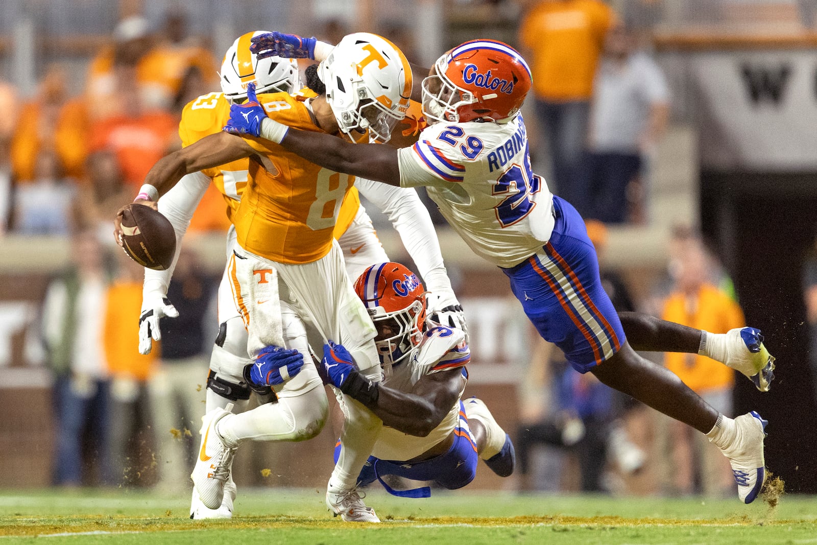 Tennessee quarterback Nico Iamaleava (8) is tackled by Florida edge George Gumbs Jr. (34) and linebacker Jaden Robinson (29) during the first half of an NCAA college football game, Saturday, Oct. 12, 2024, in Knoxville, Tenn. (AP Photo/Wade Payne)