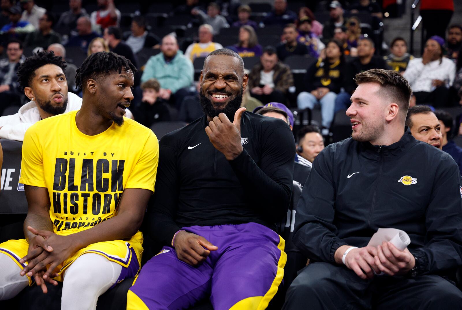 Los Angeles Lakers guard Luka Doncic, right, forwards LeBron James, center, and Dorian Finney-Smith laugh on the bench during an NBA basketball game against the Los Angeles Clippers, Tuesday, Feb. 4, 2025, in Inglewood, Calif. (AP Photo/Kevork Djansezian)