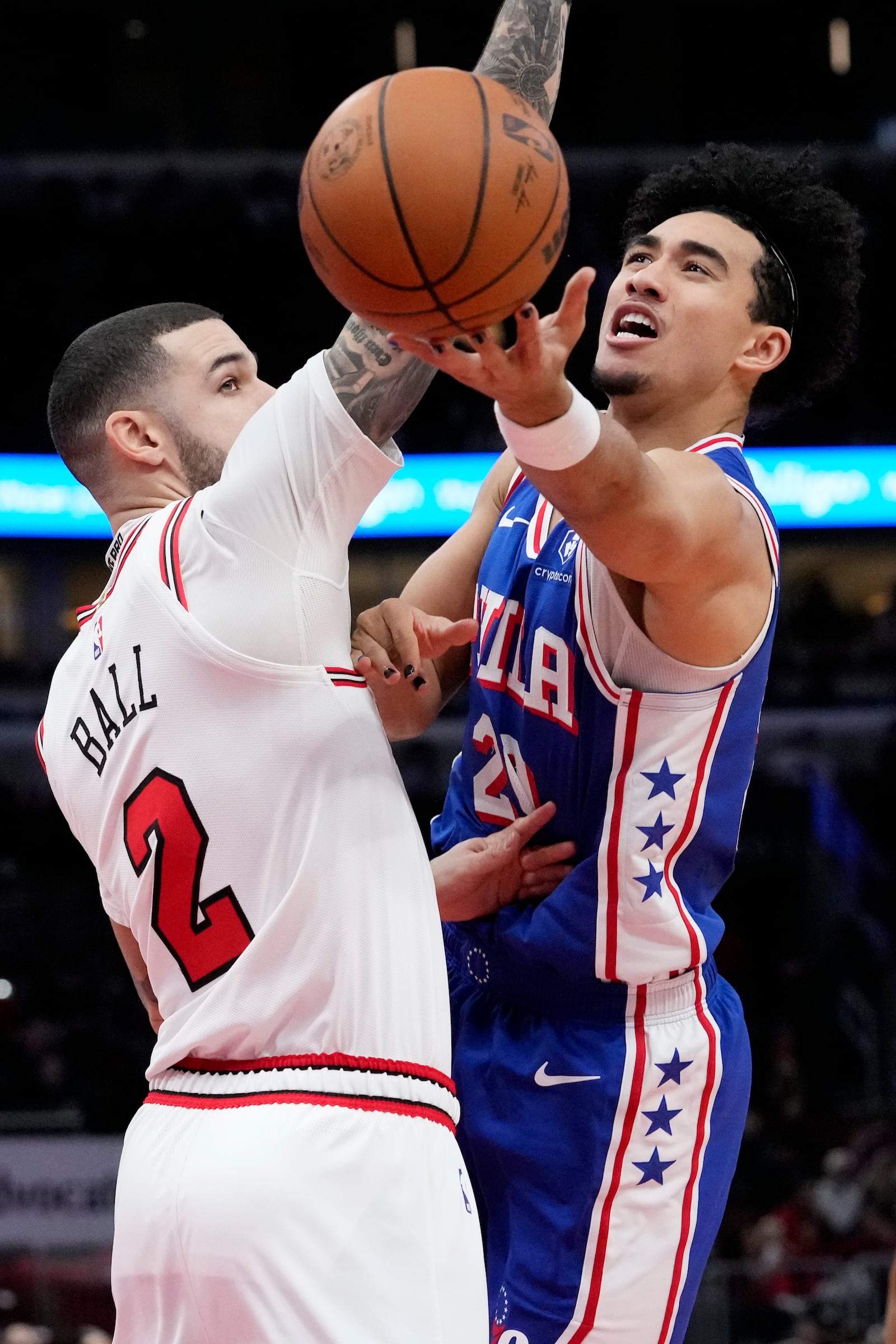 Philadelphia 76ers guard Jared McCain, right, shoots against Chicago Bulls guard Lonzo Ball during the first half of an NBA basketball game in Chicago, Sunday, Dec. 8, 2024. (AP Photo/Nam Y. Huh)