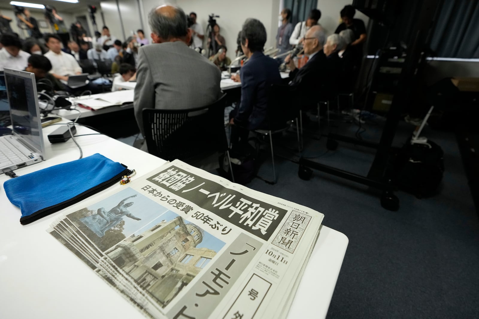 Copies of an extra version of Asahi Shimbun newspaper with the headline "Hindakyo wins Nobel Peace Prize" lie on a table during a press conference in Tokyo, Saturday, Oct. 12, 2024, a day after Nihon Hidankyo, an organization of survivors of the two U.S. atomic bombings, won the Nobel Peace Prize. (AP Photo/Hiro Komae)