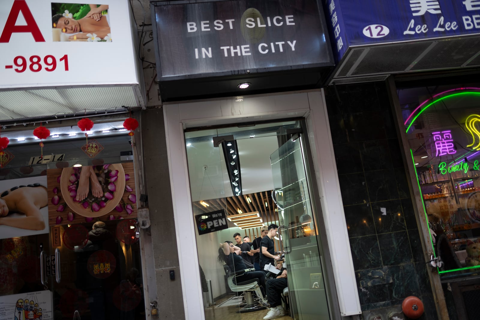 Barbers work on their clients at 12 Pell, a local barbershop in Manhattan's Chinatown, Thursday, Jan. 25, 2024, in New York. (AP Photo/John Minchillo)