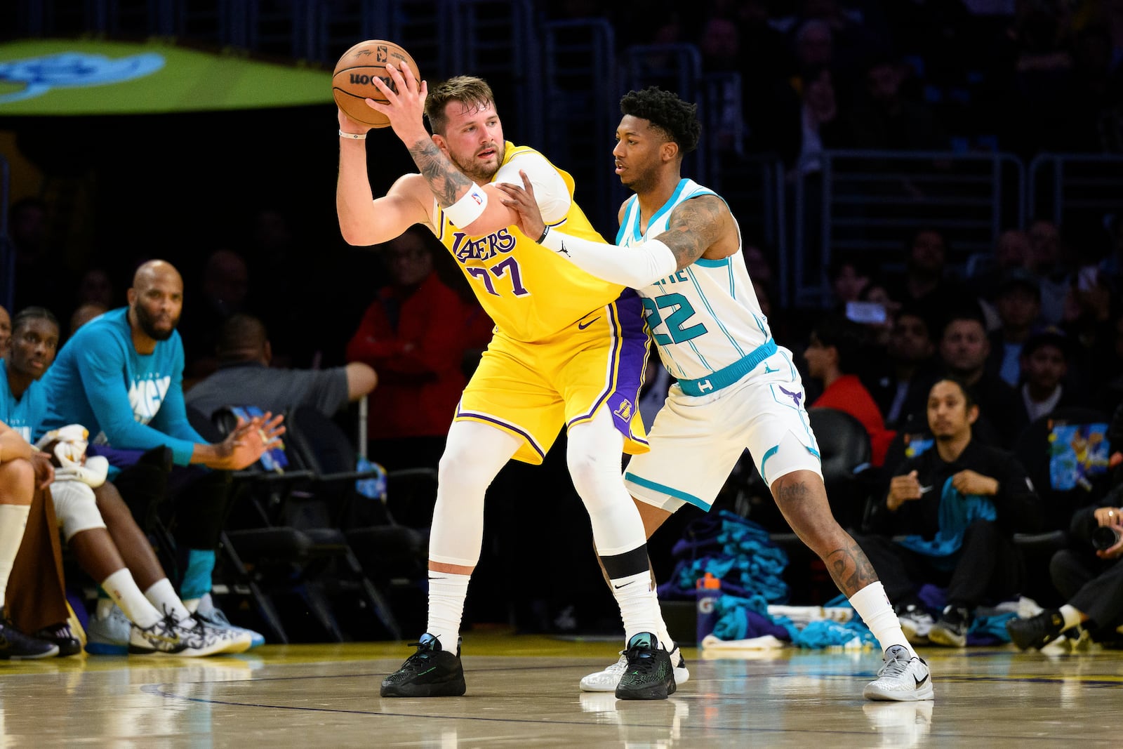 Los Angeles Lakers guard Luka Doncic (77) looks to drive the ball against Charlotte Hornets guard Elfrid Payton during the first half of an NBA basketball game Wednesday, Feb. 19, 2025, in Los Angeles. (AP Photo/William Liang)