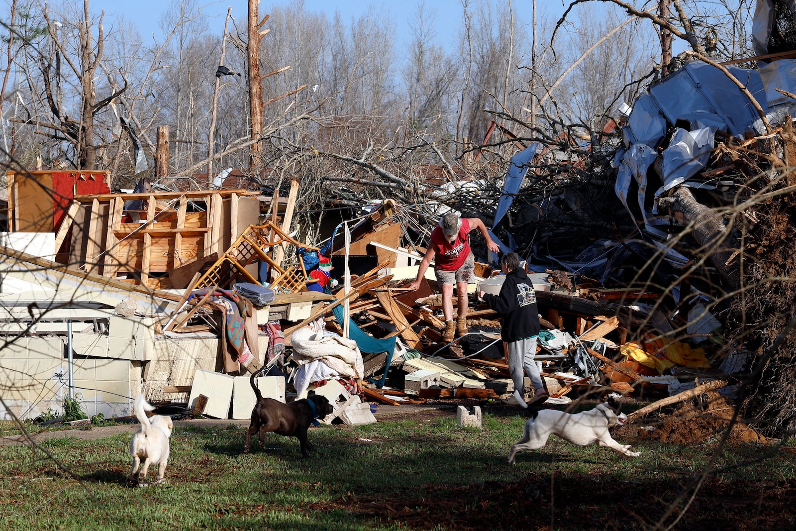 Emily and Tony Robertson look for personal belongings in the damage after a tornado passed through, Sunday, March 16, 2025, in Plantersville, Ala. (AP Photo/Butch Dill)