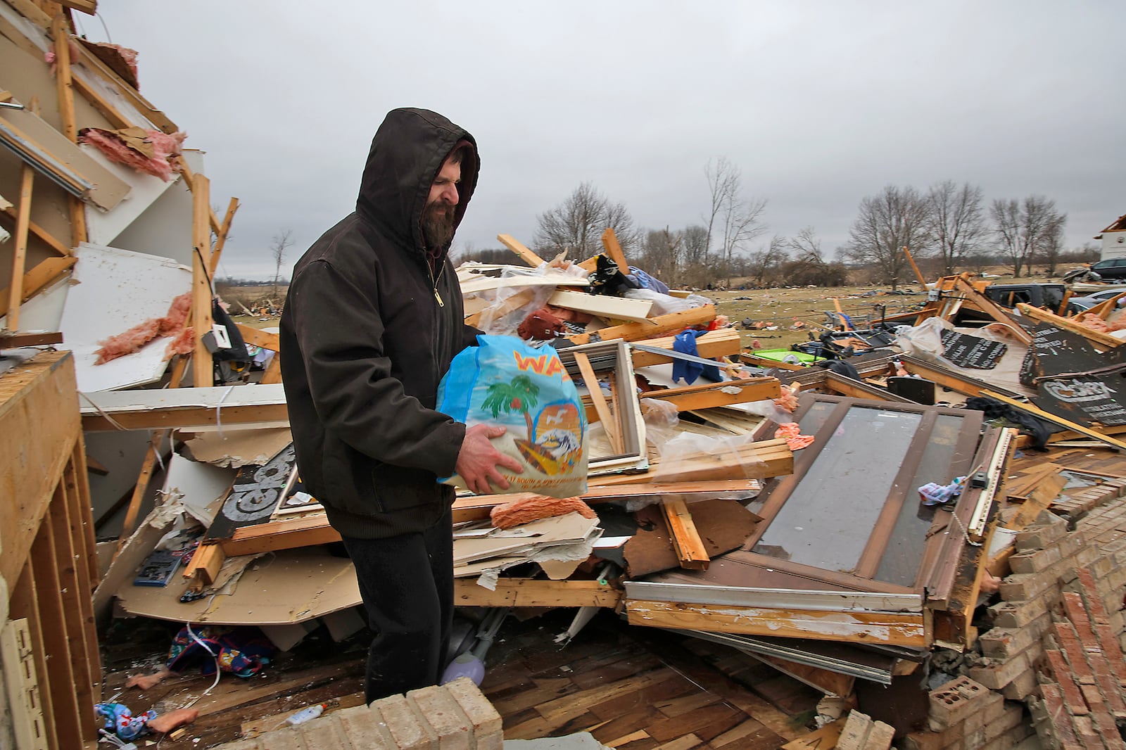 John Stewart tries to salvage some personal items from his family's home that was destroyed by a tornado Wednesday, Feb. 28, 2024 along Mitchell Road. BILL LACKEY/STAFF