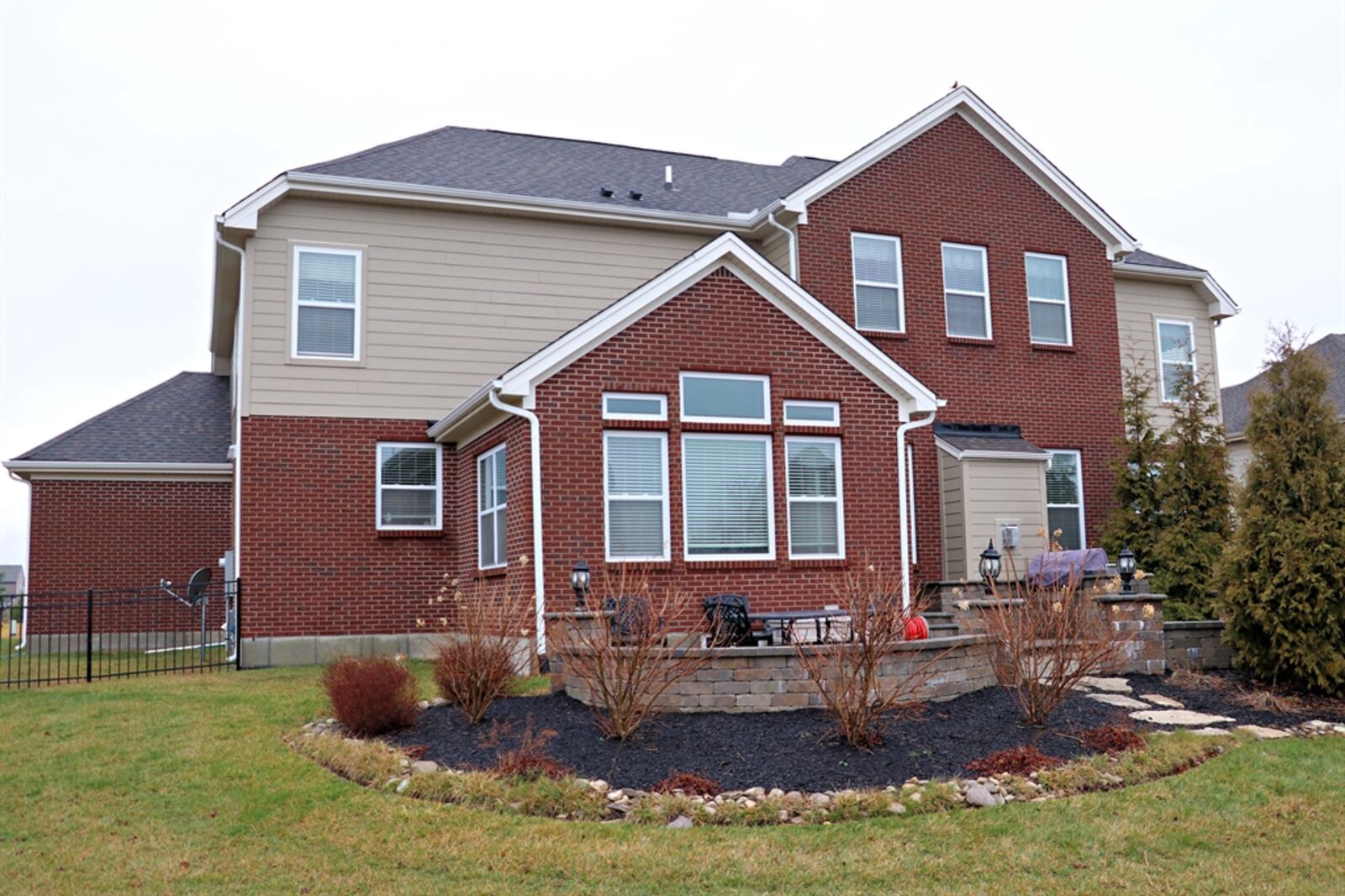 A mental fence surrounds the backyard and evergreen trees surround part of the paver-brick patio for added privacy.