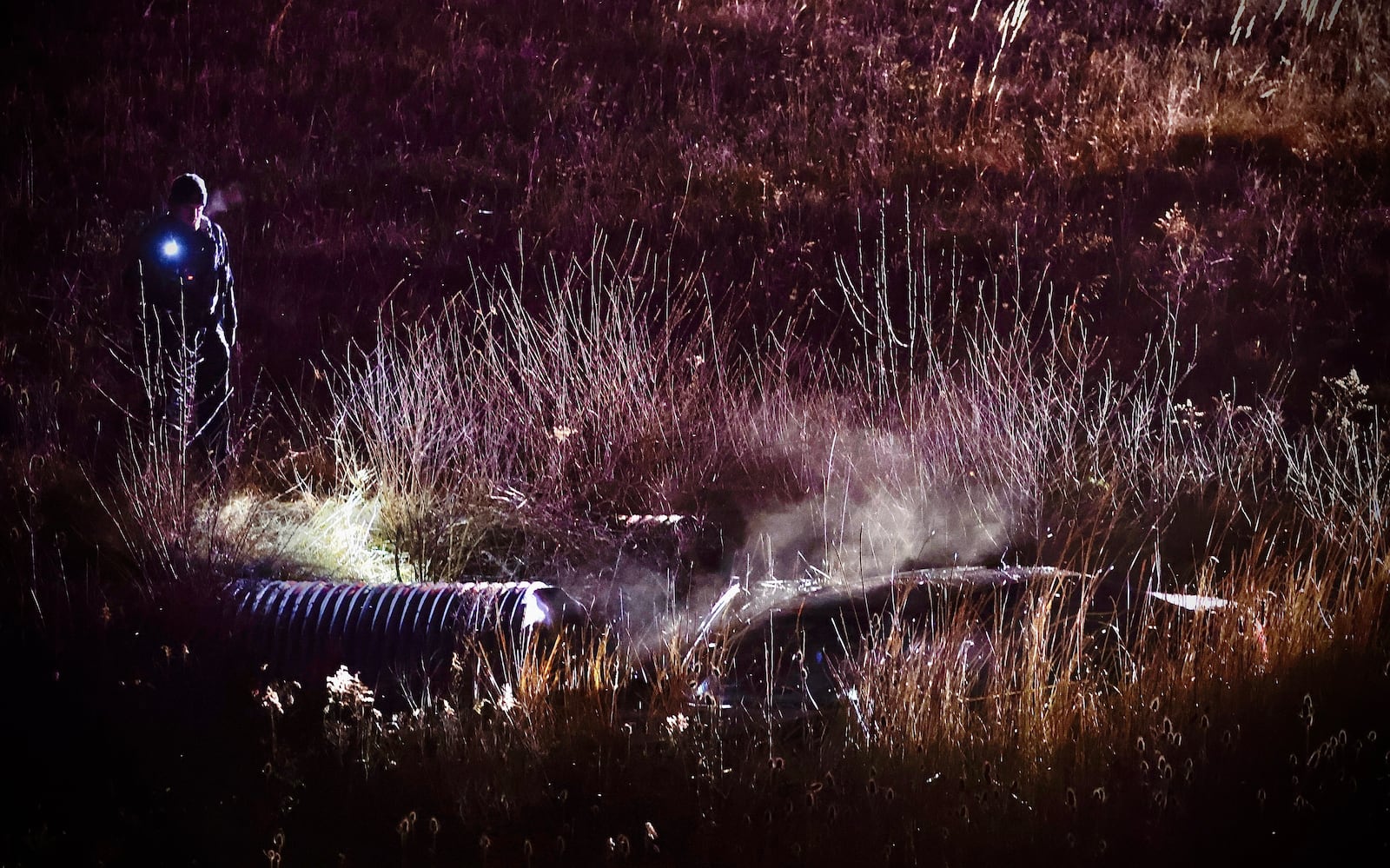 A Clark County Sheriff's deputy looks over a car that’s in a ditch along U.S. 68 near Ohio 41 in Clark County on Monday, January 1, 2025. MARSHALL GORBY \STAFF