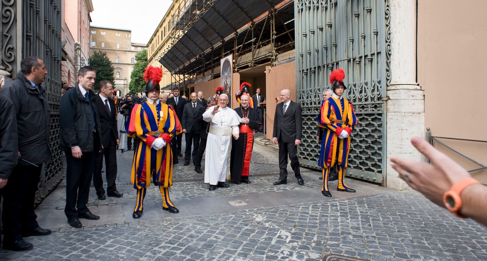 FILE - In this March 17, 2013 file photo, Pope Francis, center left, waves to faithful by making an impromptu appearance to the public from a side gate of the Vatican, startling passersby and prompting cheers, at the Vatican. (AP Photo/Antonello Nusca, file)