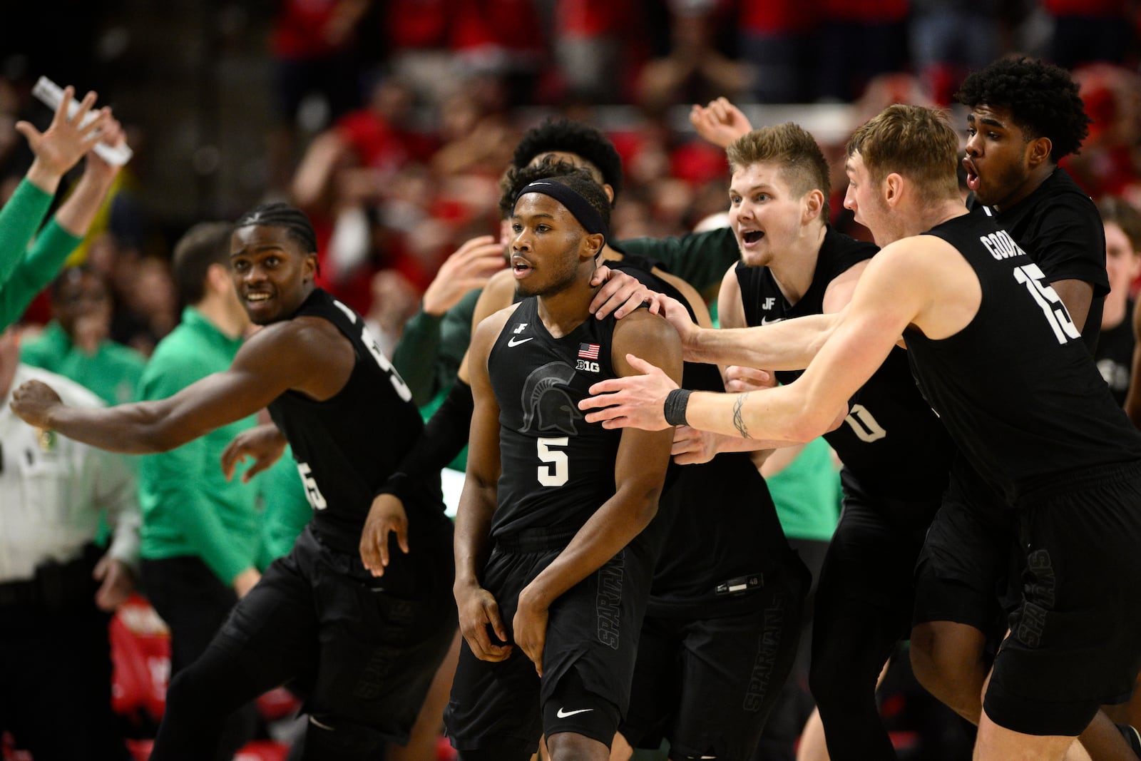 Michigan State guard Tre Holloman (5) and teammates celebrate after he made a game-winning basket to win the game at the buzzer during the second half of an NCAA college basketball game against Maryland, Wednesday, Feb. 26, 2025, in College Park, Md. (AP Photo/Nick Wass)