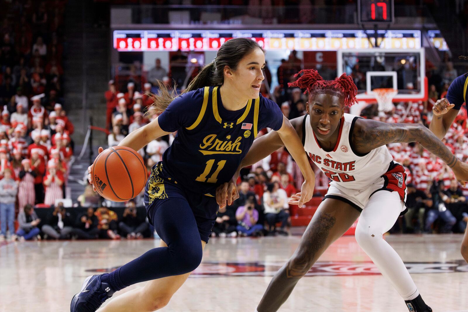 Notre Dame's Sonia Citron (11) drives as NC State's Saniya Rivers (22) defends during the first half of an NCAA college basketball game in Raleigh, N.C., Sunday, Feb. 23, 2025. (AP Photo/Ben McKeown)