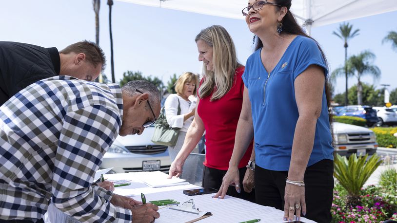 Revival Fellowship volunteers Janie Booth, left, and Lucky Harutunian register voters during a Comeback California Tour event, Saturday, Sept. 21, 2024, in Menifee, Calif. (AP Photo/Zoë Meyers)