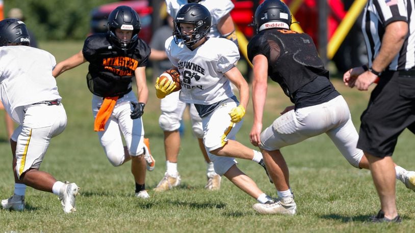 Cutline: Shawnee High School senior Connar Earles runs the ball between two Minster defenders during their scrimmage on Saturday, Aug. 10 in Springfield. Michael Cooper/CONTRIBUTED