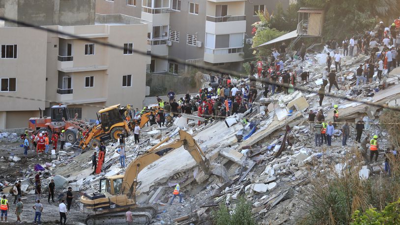 FILE - People and rescue teams search for victims after an Israeli airstrike hit two adjacent buildings, in Ain el-Delb neighbourhood east of the southern port city of Sidon, Lebanon, Sunday, Sept. 29, 2024. (AP Photo/Mohammed Zaatari, File)