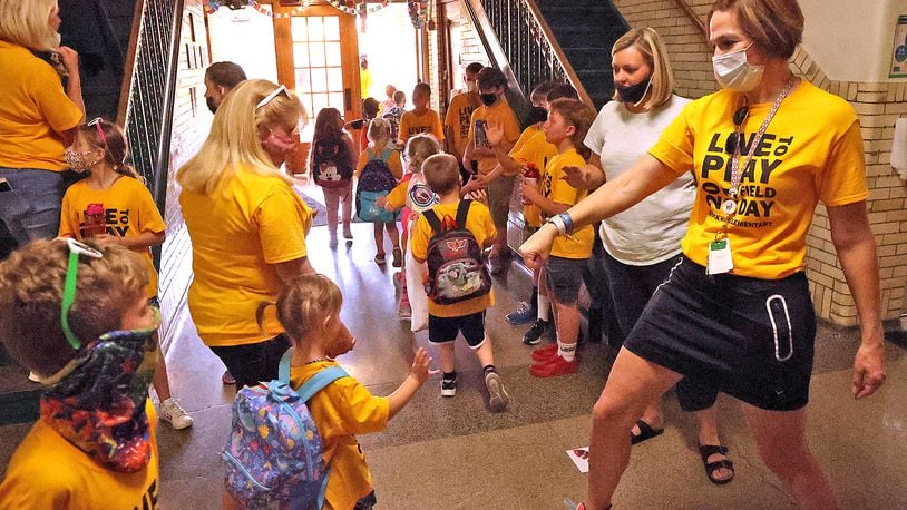 Rockway Elementary School principal, Mandy Shaffer, gives preschool students a fist bump as they leave Rockway for the last time. Clark and Champaign school districts will soon start their summer learning plans. What does this mean for masks in schools? BILL LACKEY/STAFF