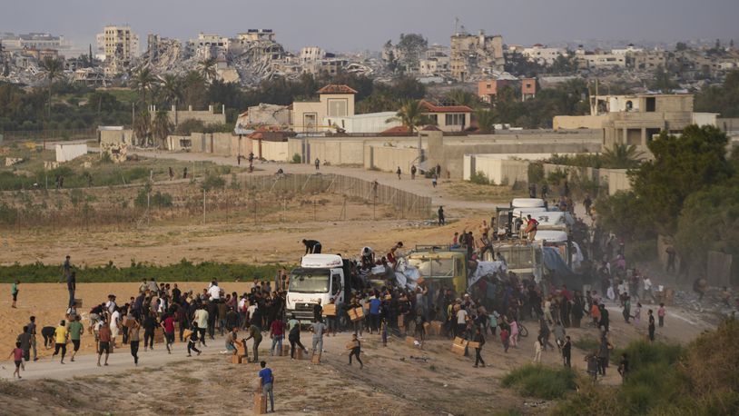 FILE - Palestinians are storming trucks loaded with humanitarian aid brought in through a new U.S.-built pier, in the central Gaza Strip, May 18, 2024. (AP Photo/Abdel Kareem Hana, File)