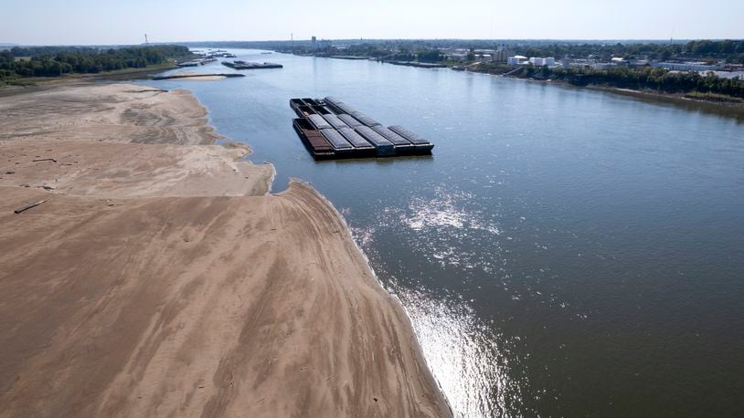 FILE - Barges float in the Mississippi River as a portion of the riverbed is exposed, on Sept. 15, 2023, in St. Louis. The U.N. weather agency is reporting that 2023 was the driest year in more than three decades for the world's rivers, as the record-hot year underpinned a drying up of water flows and contributed to prolonged droughts in some places. (AP Photo/Jeff Roberson, File)