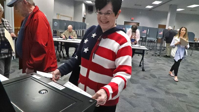 Marilyn Milbrandt was wearing her patriotic sweater as she puts her ballot in the voting machine during the May primary at the Champaign County Board of Elections. BILL LACKEY/STAFF