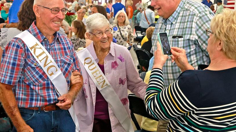 Fletcher and Roberta Mowell get their picture taken as the make their way through the crowd after being crowned King and Queen of the Golden Wedding Party Tuesday, July 23. 2024 at the Clark County Fair. Harold and Roberta have been married for 70 years. BILL LACKEY/STAFF