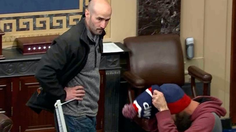 In this image from Senate Television, Leo Christopher Kelly, walks on the floor in the Senate chamber Jan. 6, 2021, at the U.S. Capitol in Washington. The federal Bureau of Prisons mistakenly released Kelly from custody before he finished serving his 30-month sentence for storming the Senate chamber during a mob's attack on the U.S. Capitol, Justice Department prosecutors said in a court filing. (Senate Television via AP)