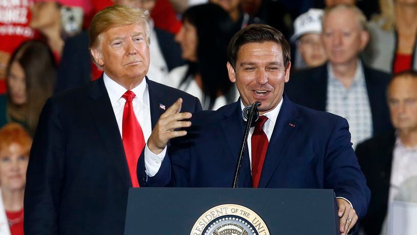FILE- President Donald Trump stands behind gubernatorial candidate Ron DeSantis at a rally in Pensacola, Fla., Nov. 3, 2018. Trump and DeSantis are signaling to donors that they're putting their rivalry behind them. DeSantis has convened his allies this week in Fort Lauderdale, Fla., to press them to support Trump. He argued to them Wednesday, May 22, 2024, that they need to work together to prevent President Joe Biden from winning a second term. (AP Photo/Butch Dill, File)