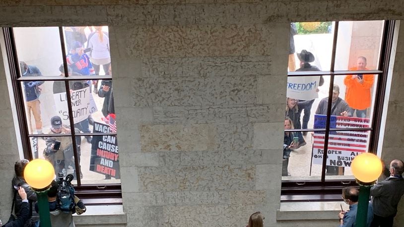 Protesters demonstrate outside the Statehouse Friday, May 1, 2020. LAURA A. BISCHOFF / STAFF