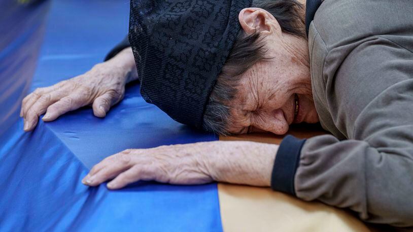 A mother cries near the coffin of her son killed in a Russian rocket attack at a Ukrainian military academy, during his funeral ceremony in Poltava, Ukraine, Saturday Sept. 7, 2024. (AP Photo/Evgeniy Maloletka)