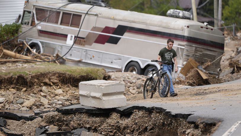 Dominick Gucciardo walks to his home in the aftermath of Hurricane Helene, Thursday, Oct. 3, 2024, in Pensacola, N.C. (AP Photo/Mike Stewart)